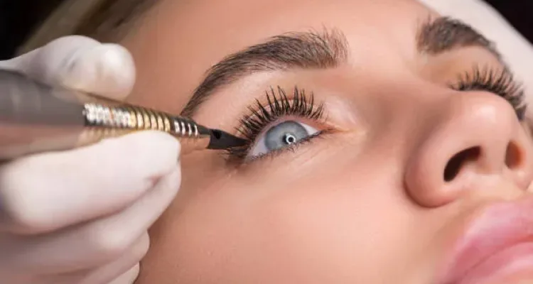 Permanent eye makeup close up shot. Cosmetologist applying tattooing of eyes. Makeup eyeliner procedure